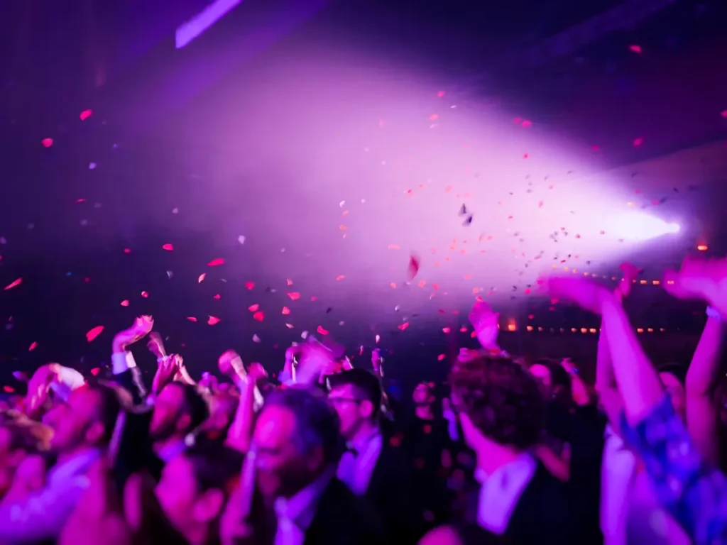 Fiesta de Fin de Año en París Multitud celebrando y bailando con confeti en una fiesta nocturna